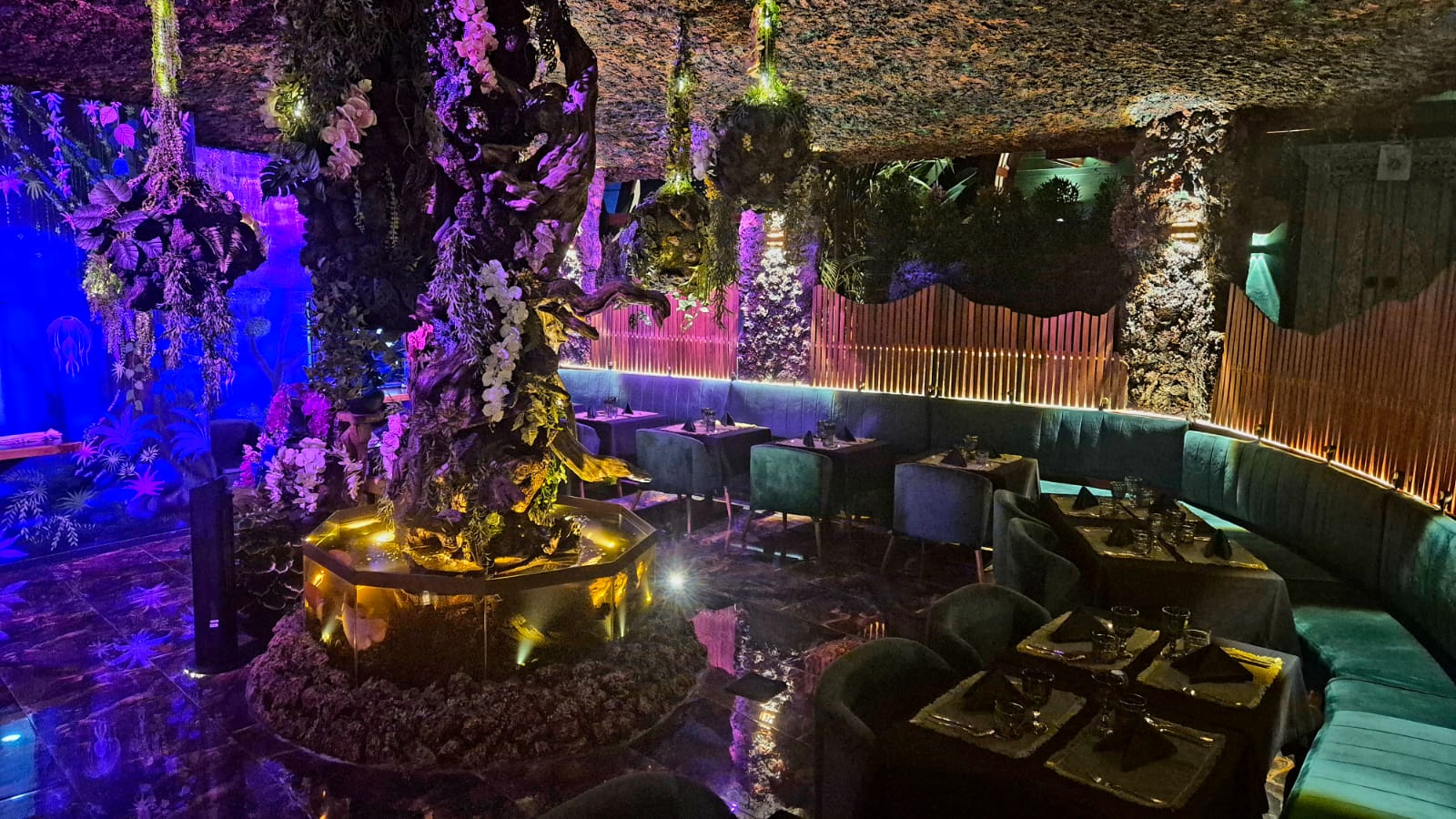 The illuminated tree and velvet banquettes of the Orama Essence dining room